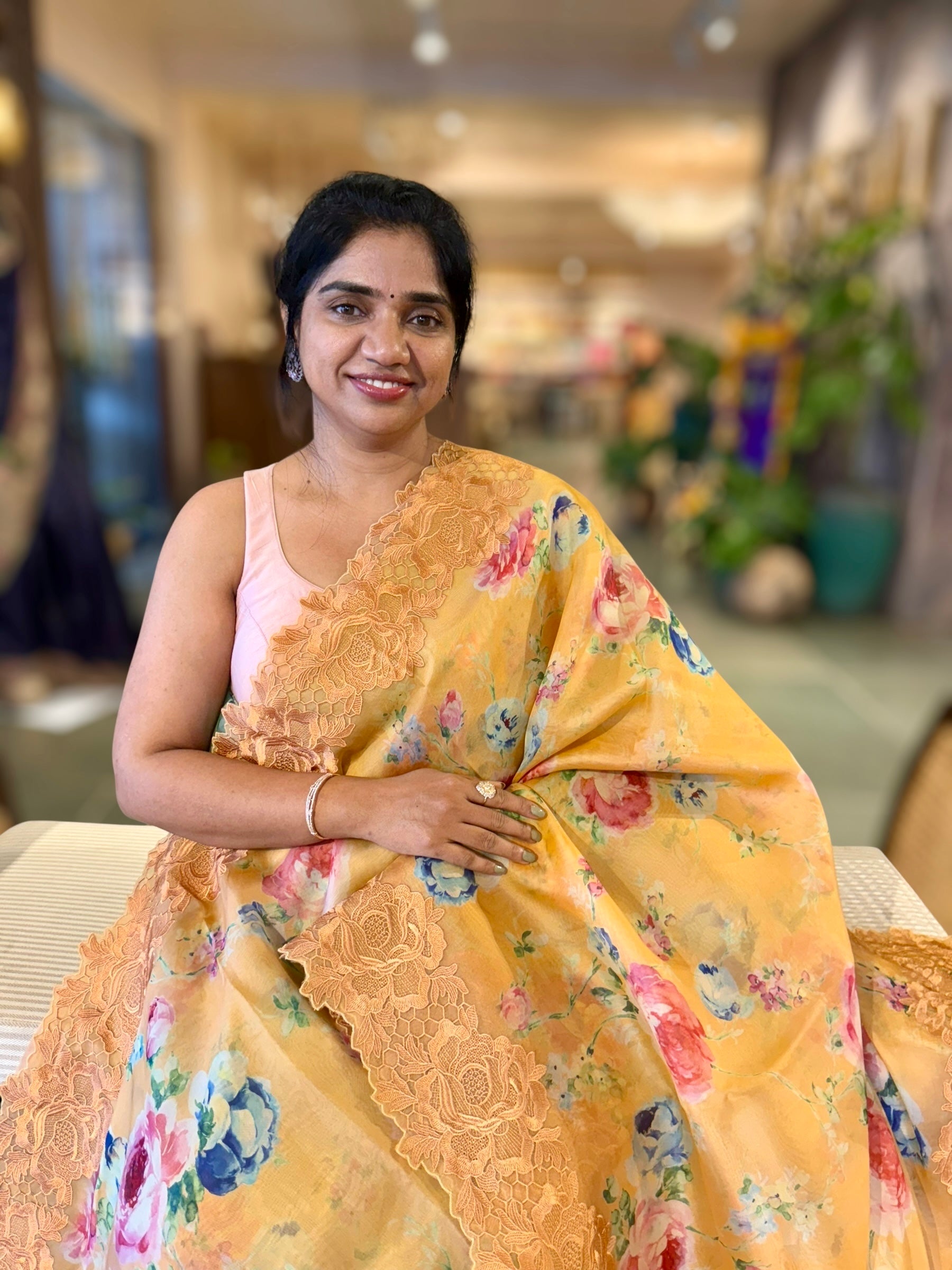 Mustardish Orange Printed Organza Saree With Chantilly Lace Style Embroidered Border.