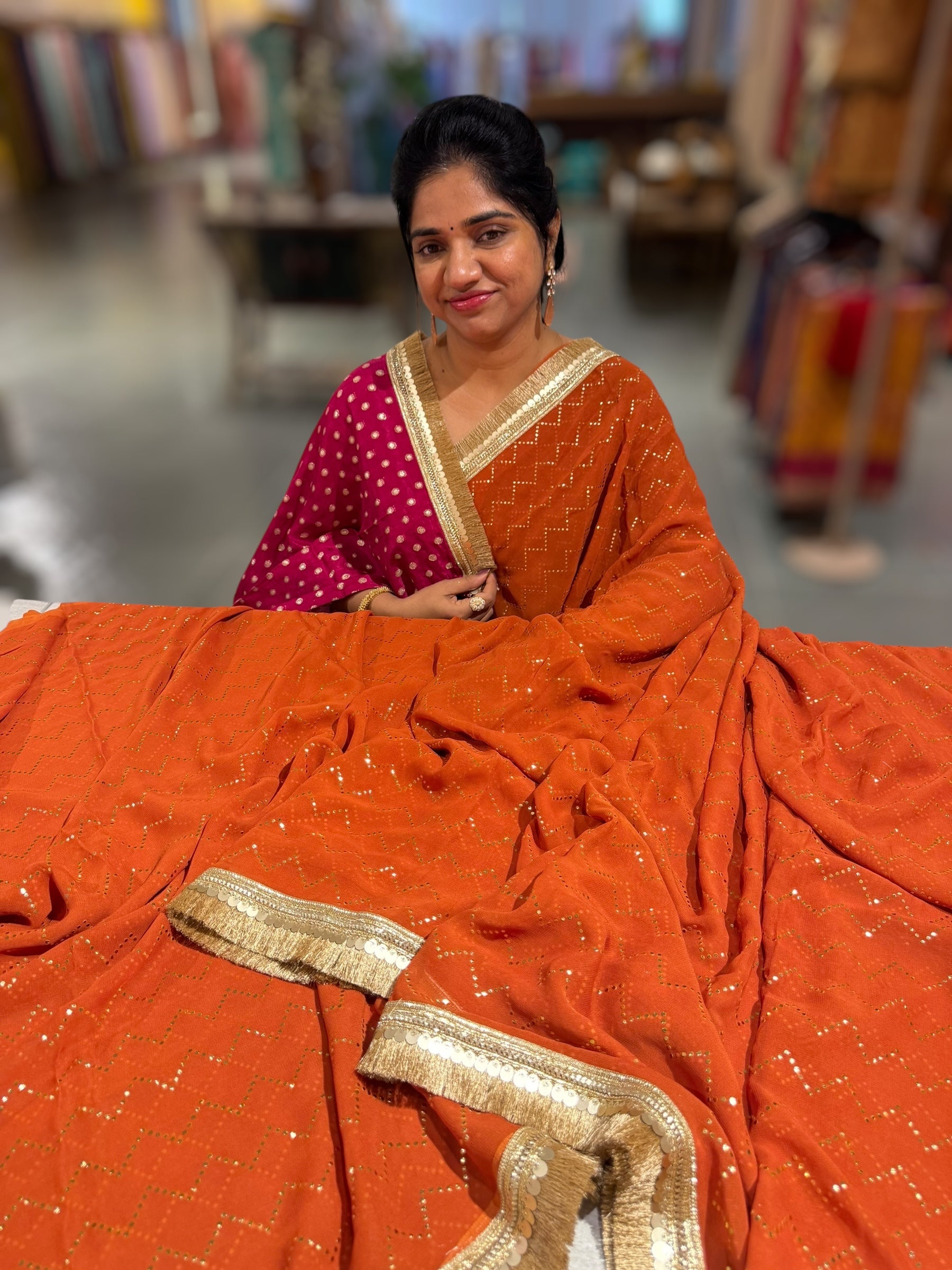Rust Orange Georgette Saree with stick on Badla in zigzag pattern
