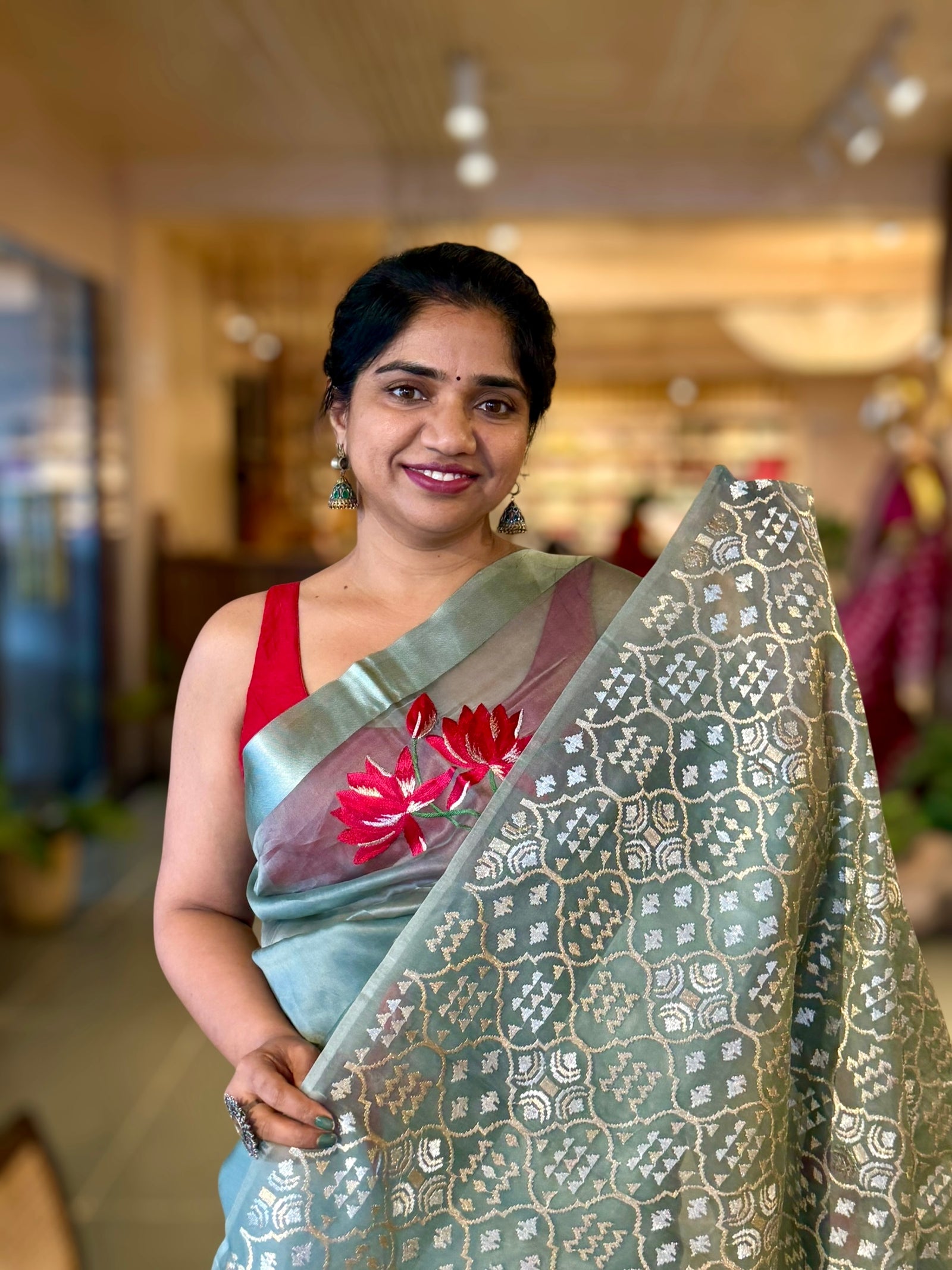 Teal Organza Saree with Lotus flower embroidery and Satin Borders.