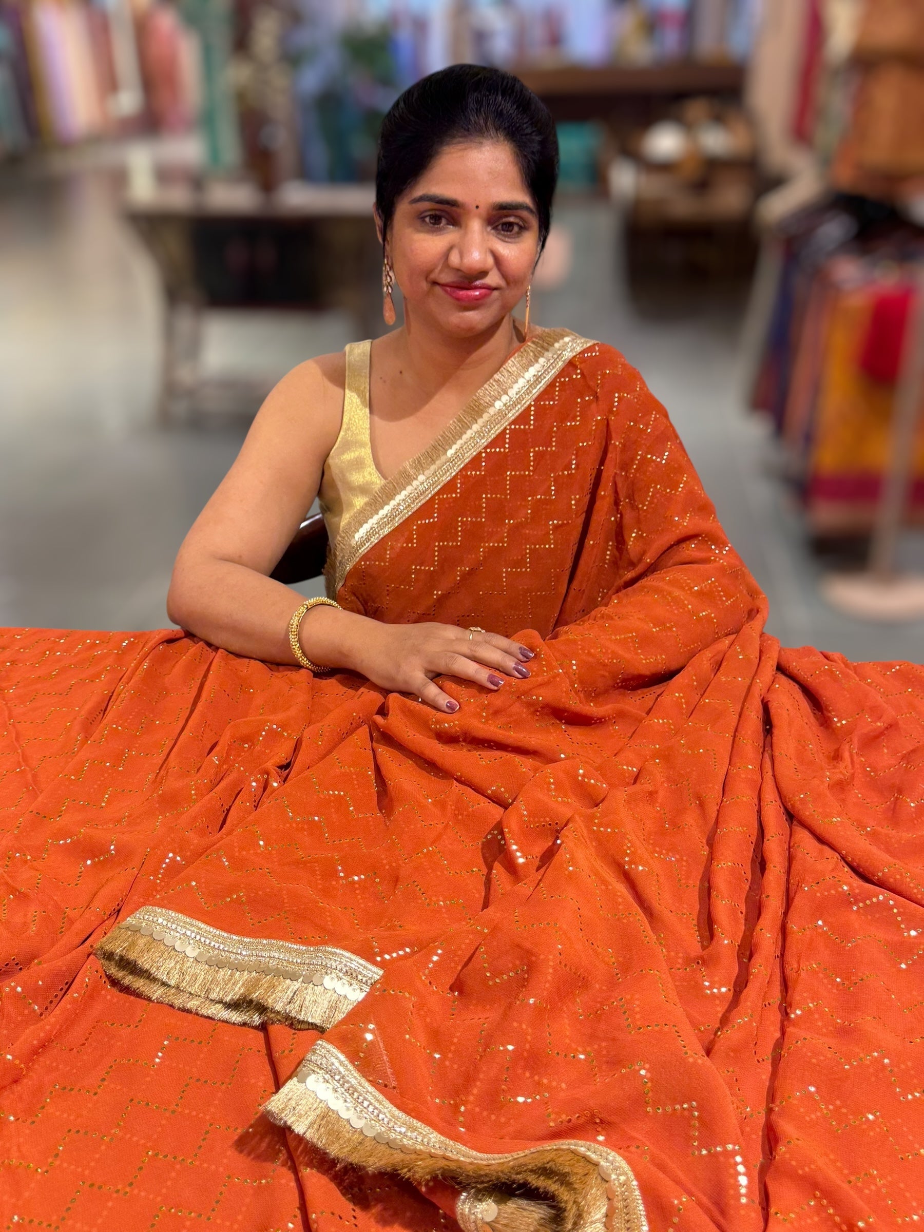Rust Orange Georgette Saree with stick on Badla in zigzag pattern
