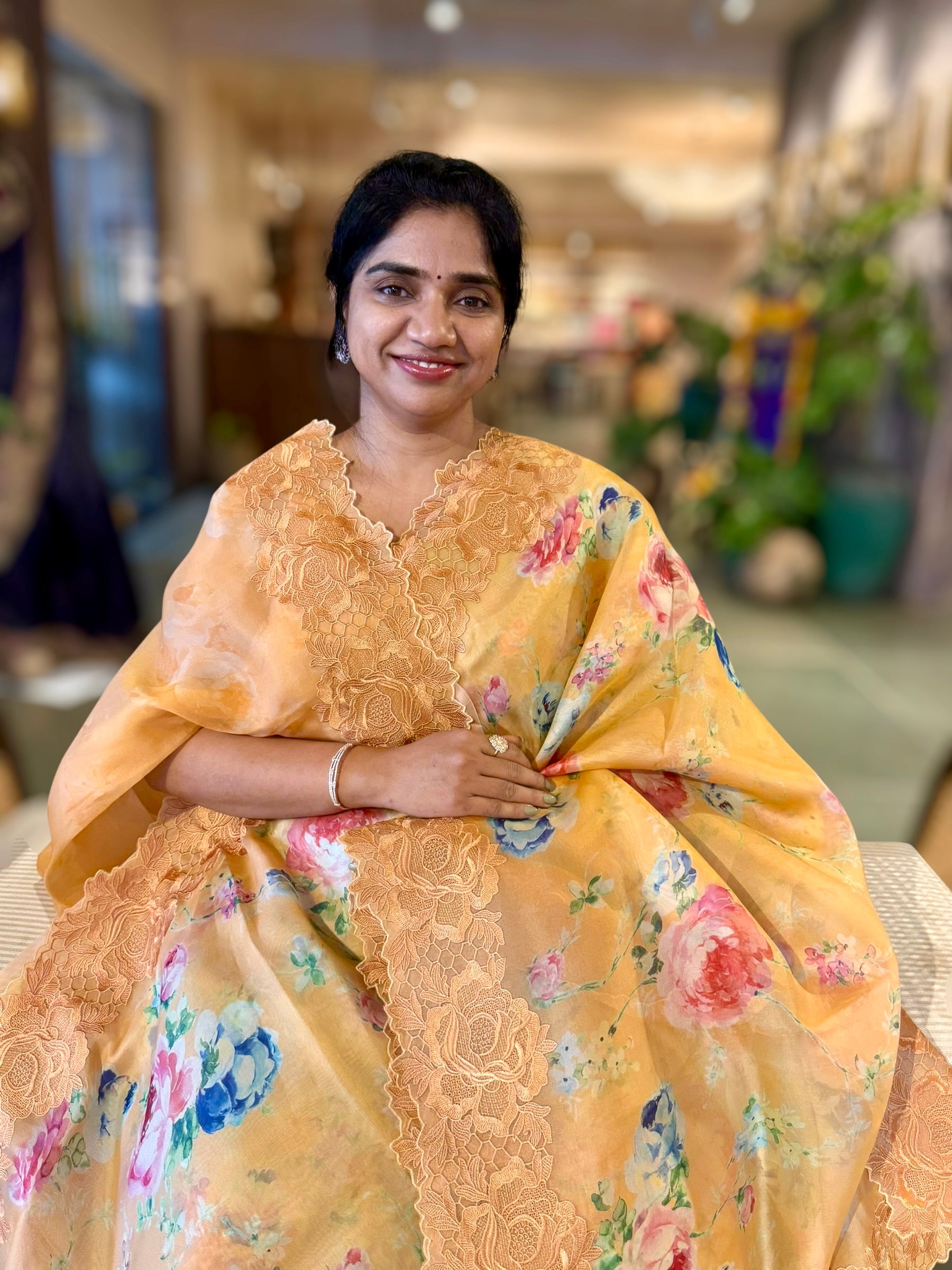 Mustardish Orange Printed Organza Saree With Chantilly Lace Style Embroidered Border.