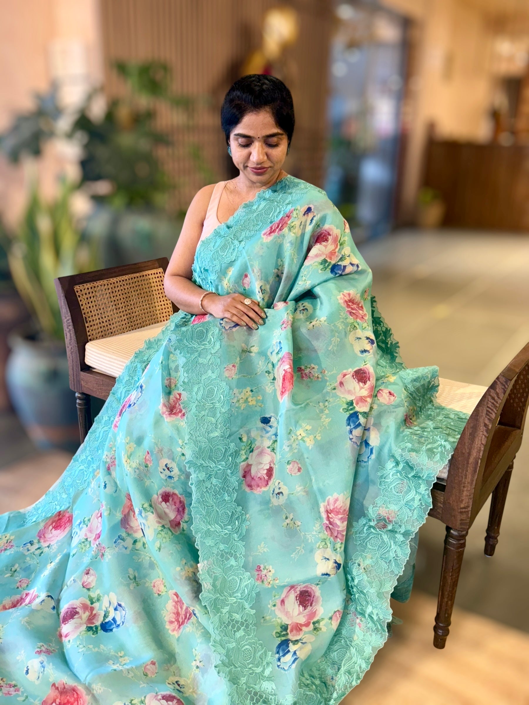 Teal Printed Organza Saree With Chantilly Lace Style Embroidered Border.