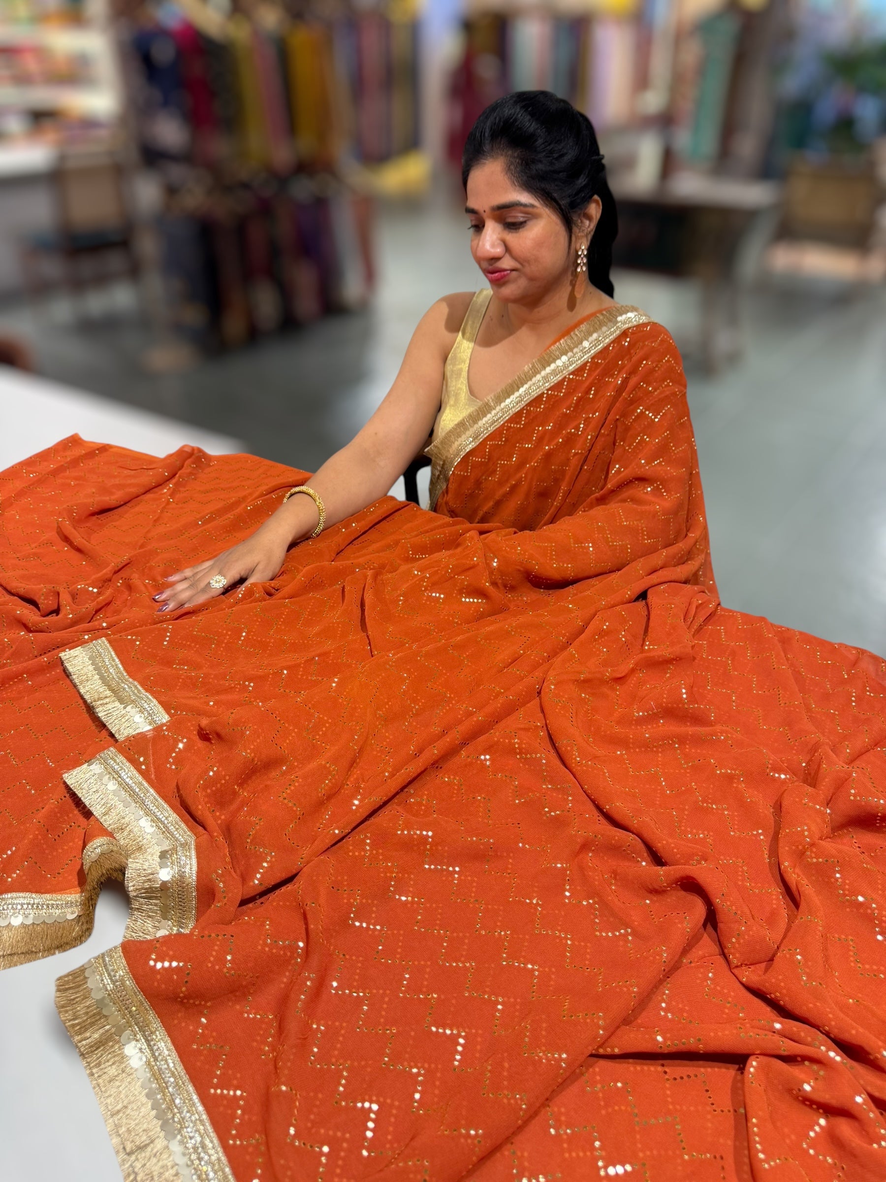 Rust Orange Georgette Saree with stick on Badla in zigzag pattern
