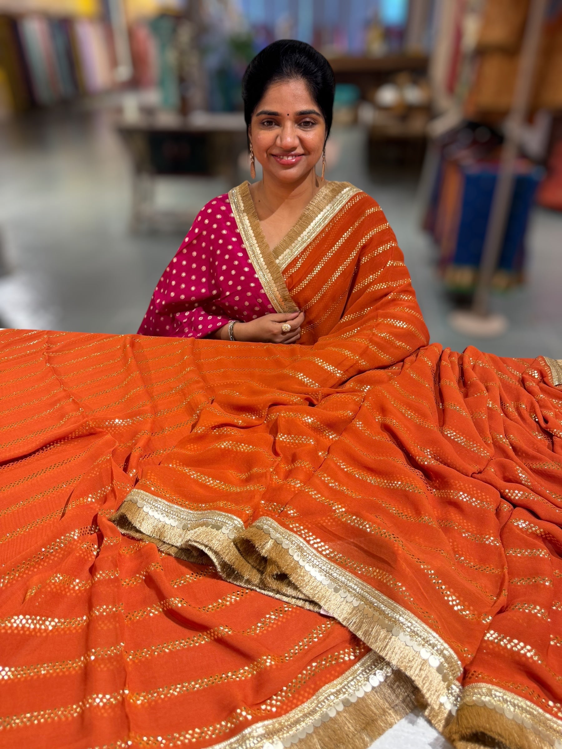 Rust Orange Georgette Saree with stick on Badla in stripes pattern and kiran Lace