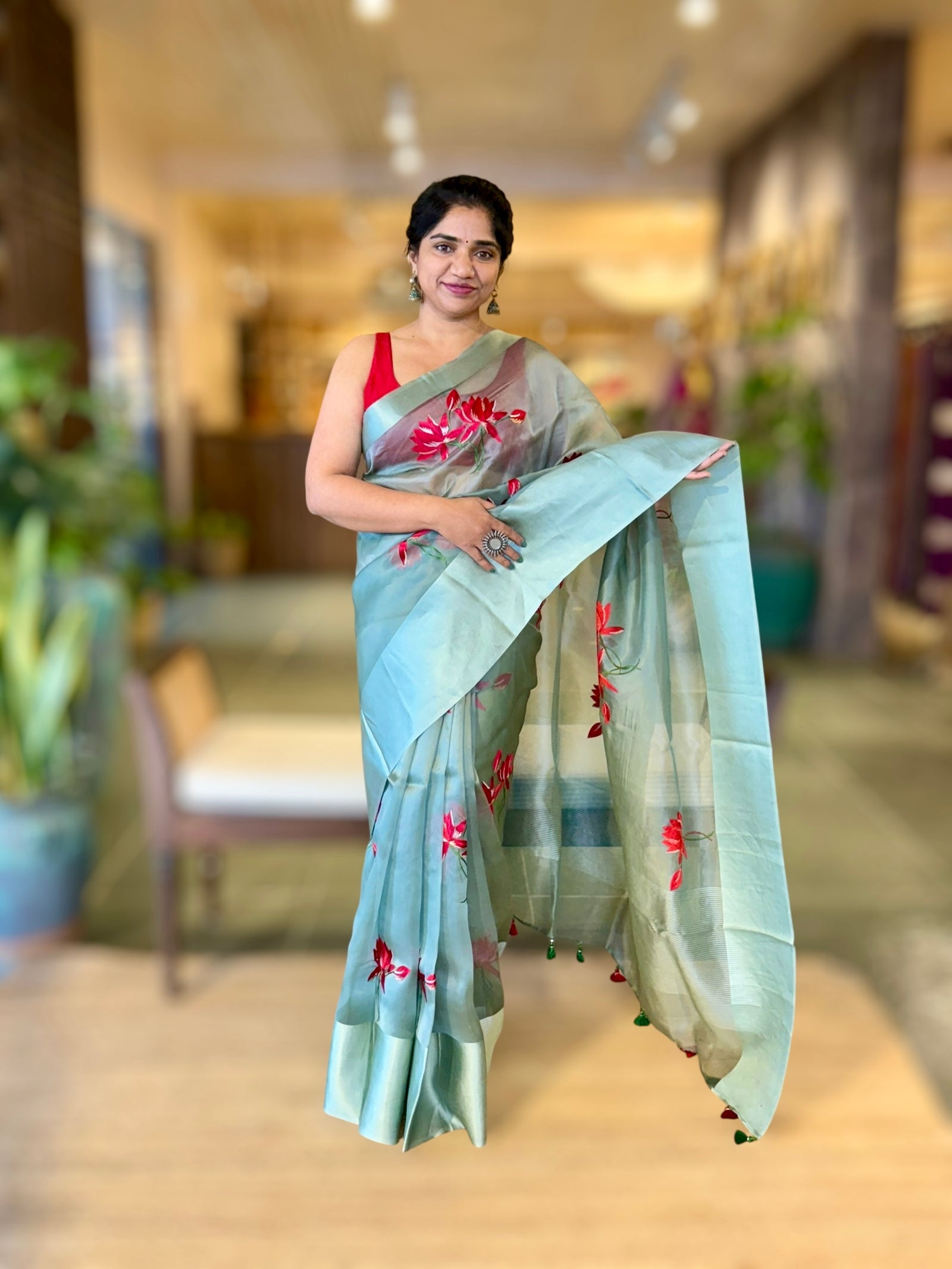 Teal Organza Saree with Lotus flower embroidery and Satin Borders.