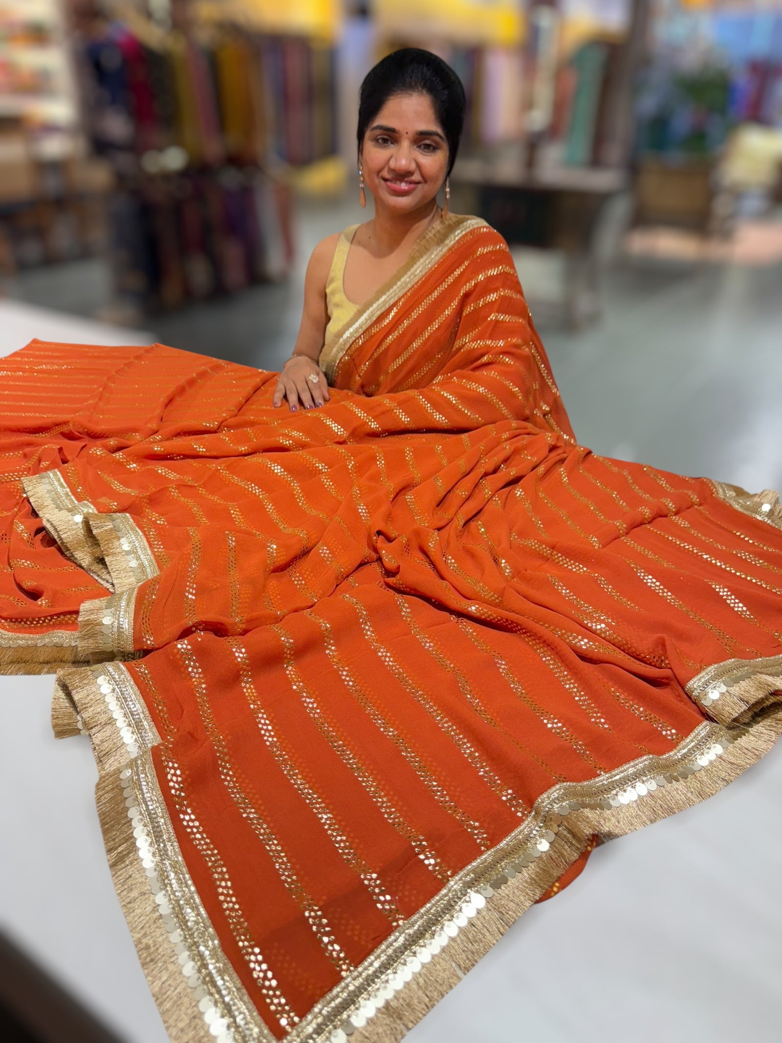 Rust Orange Georgette Saree with stick on Badla in stripes pattern and kiran Lace