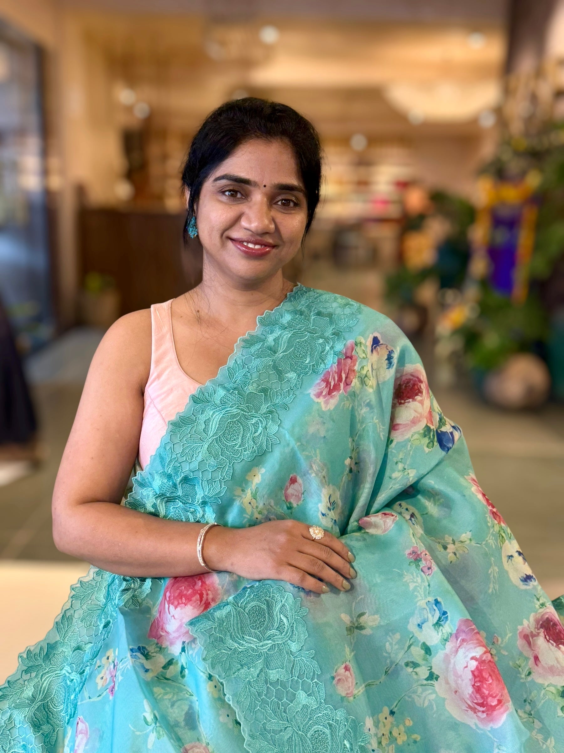Teal Printed Organza Saree With Chantilly Lace Style Embroidered Border.