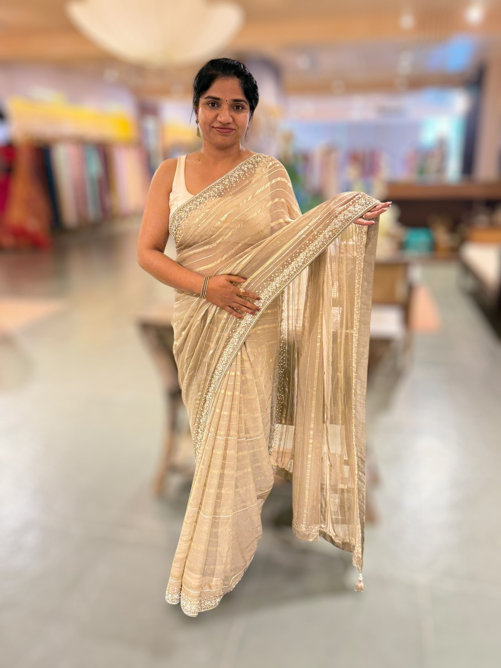 Beige chiffon saree with handwork borders and stitched blouse