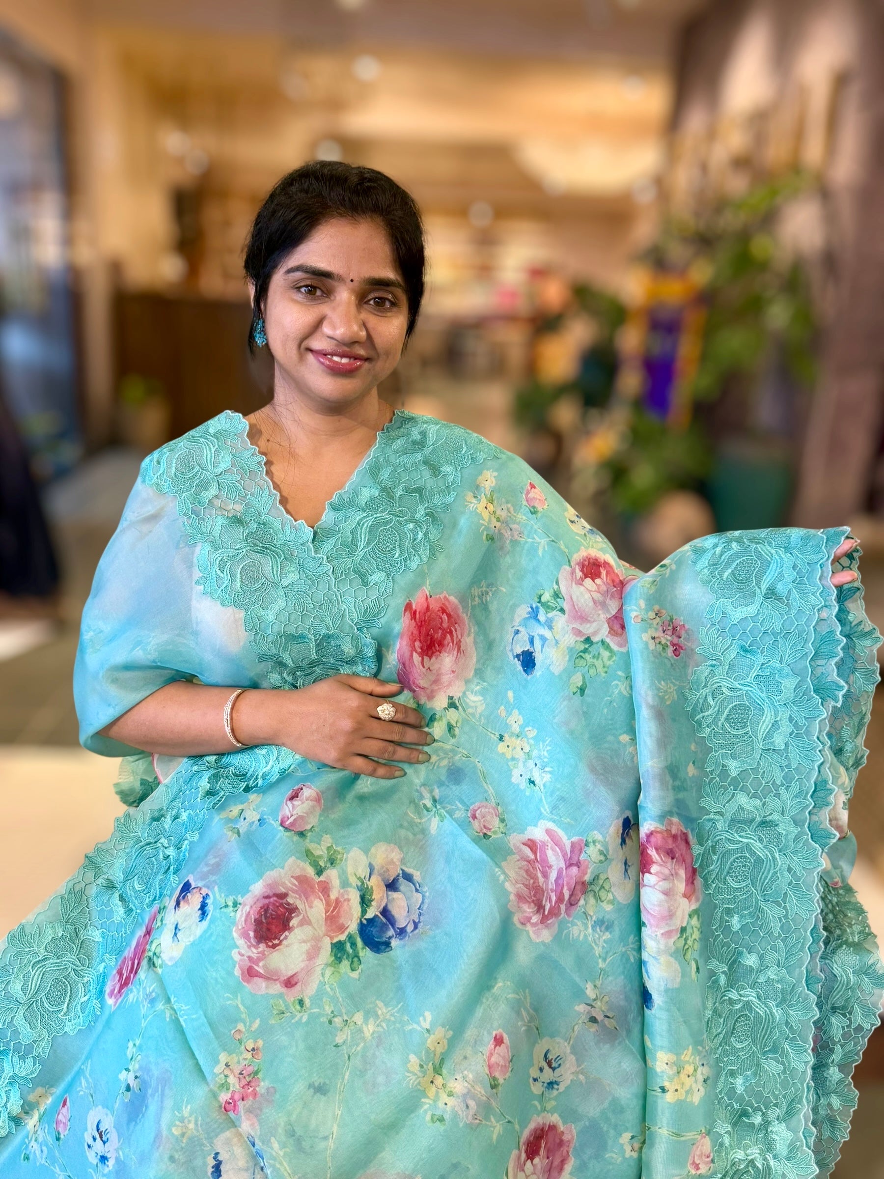 Teal Printed Organza Saree With Chantilly Lace Style Embroidered Border.