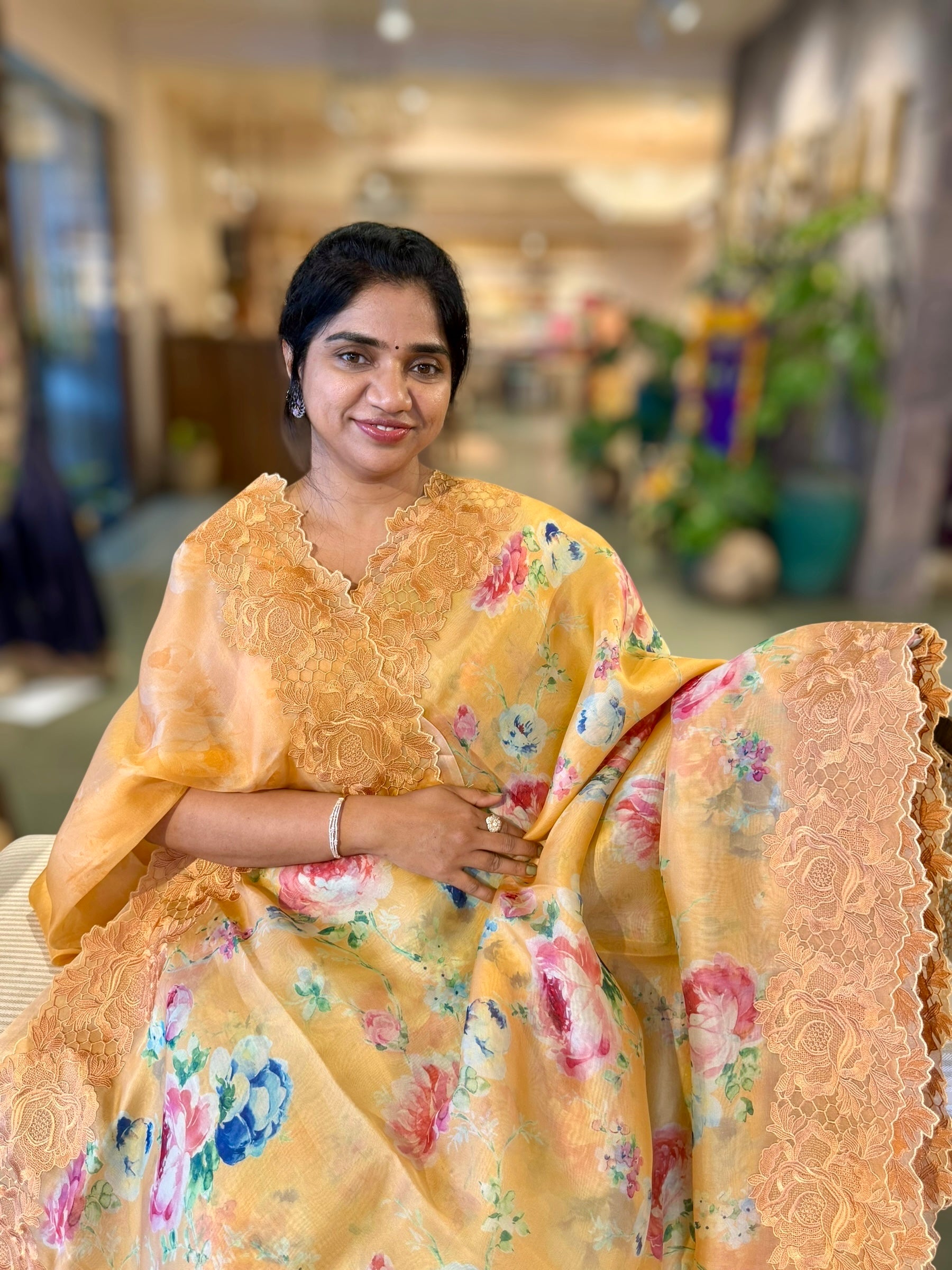 Mustardish Orange Printed Organza Saree With Chantilly Lace Style Embroidered Border.