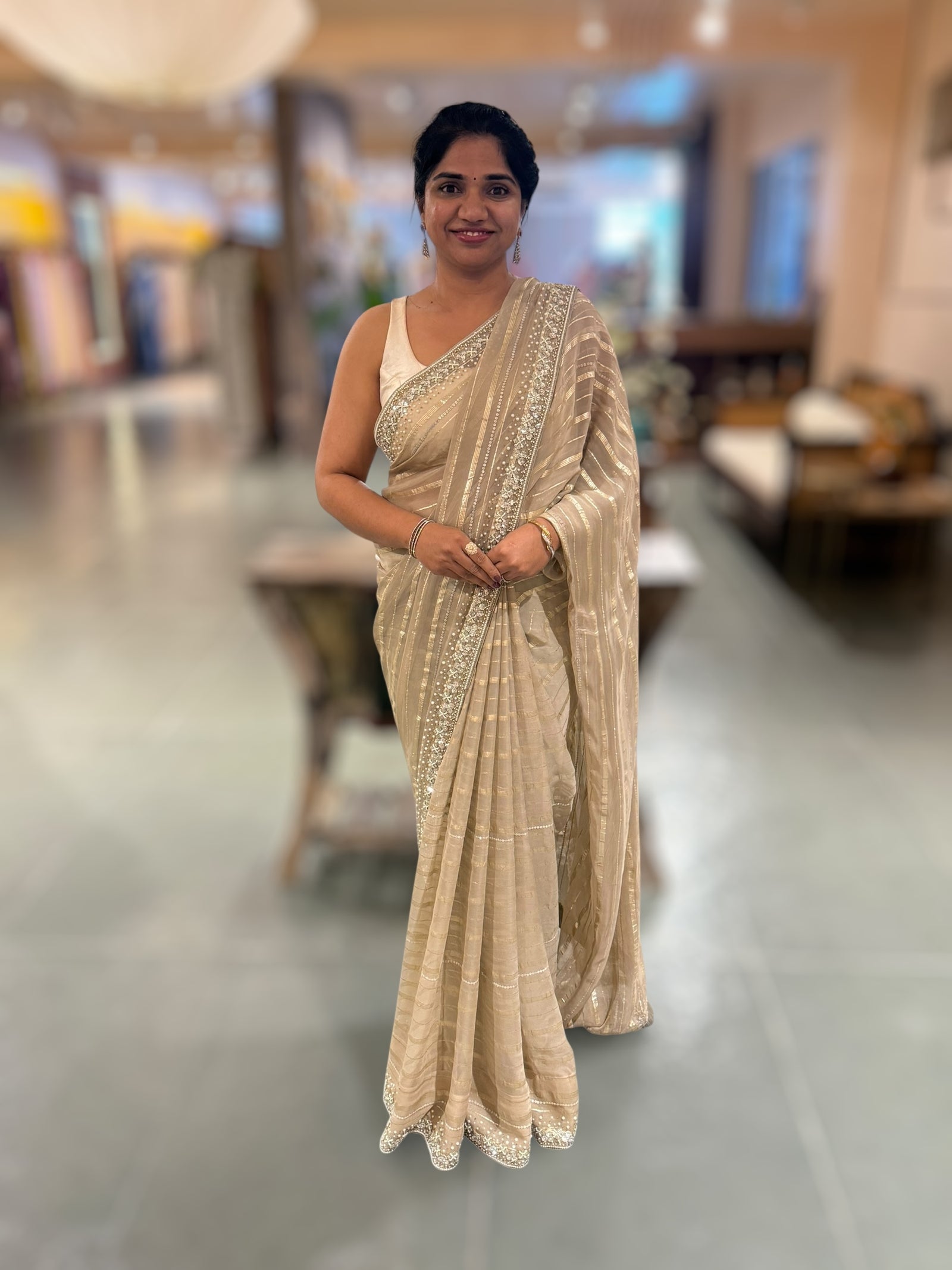 Beige chiffon saree with handwork borders and stitched blouse