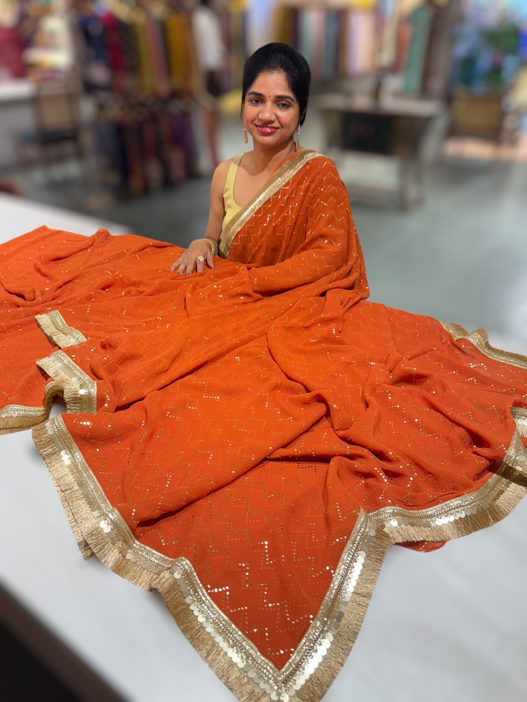 Rust Orange Georgette Saree with stick on Badla in zigzag pattern