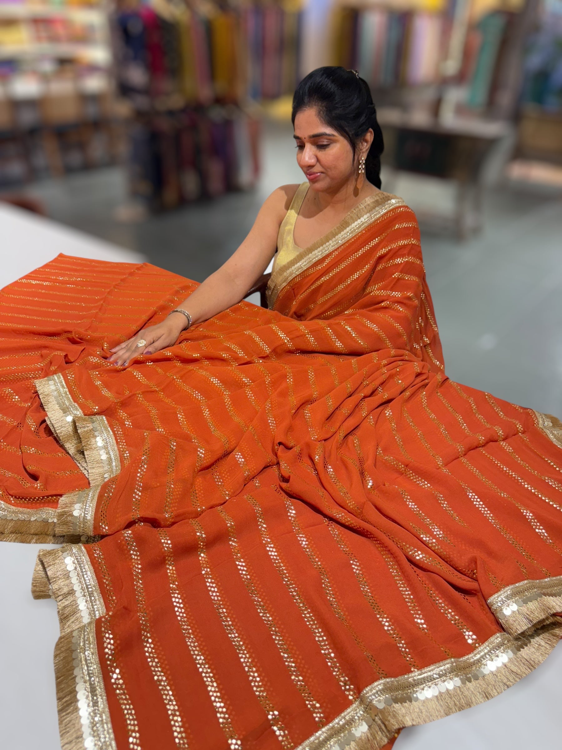 Rust Orange Georgette Saree with stick on Badla in stripes pattern and kiran Lace