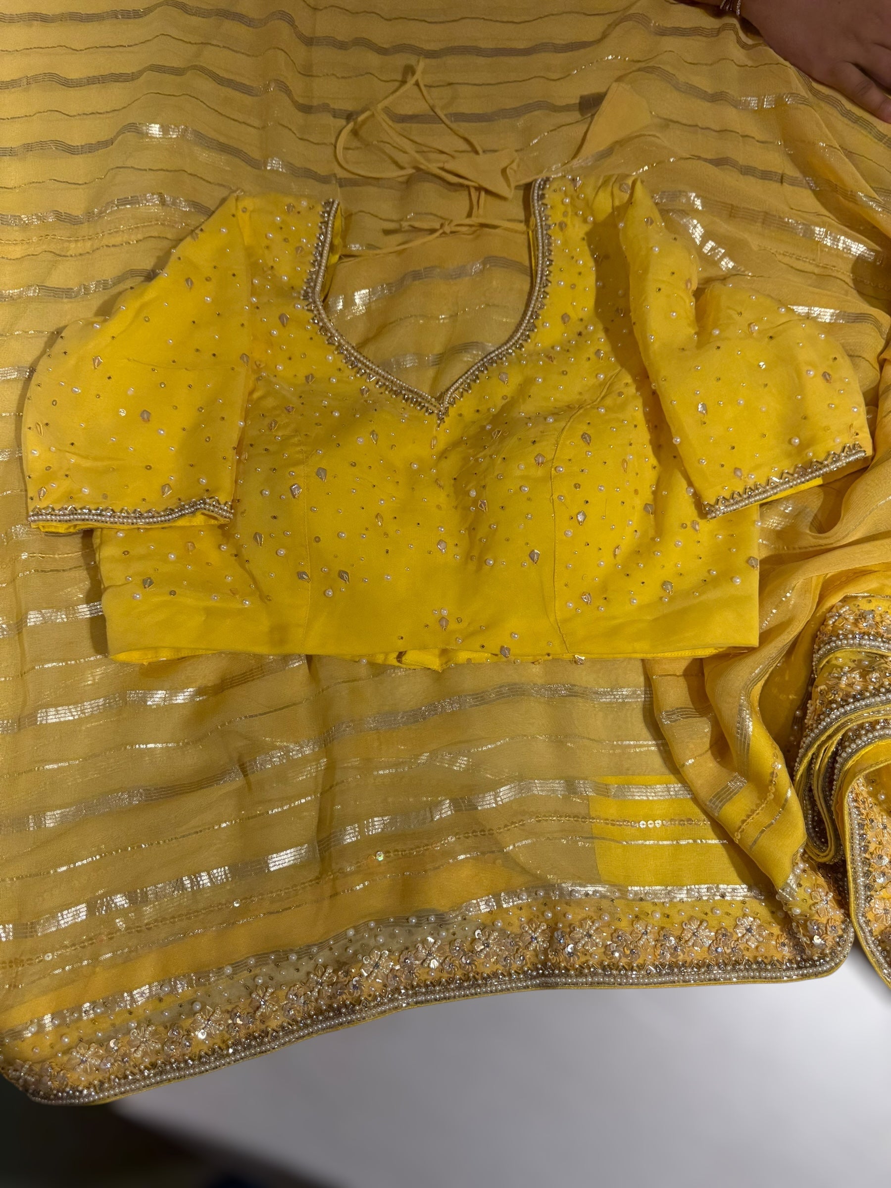 Yellow chiffon saree with handwork borders and stitched blouse