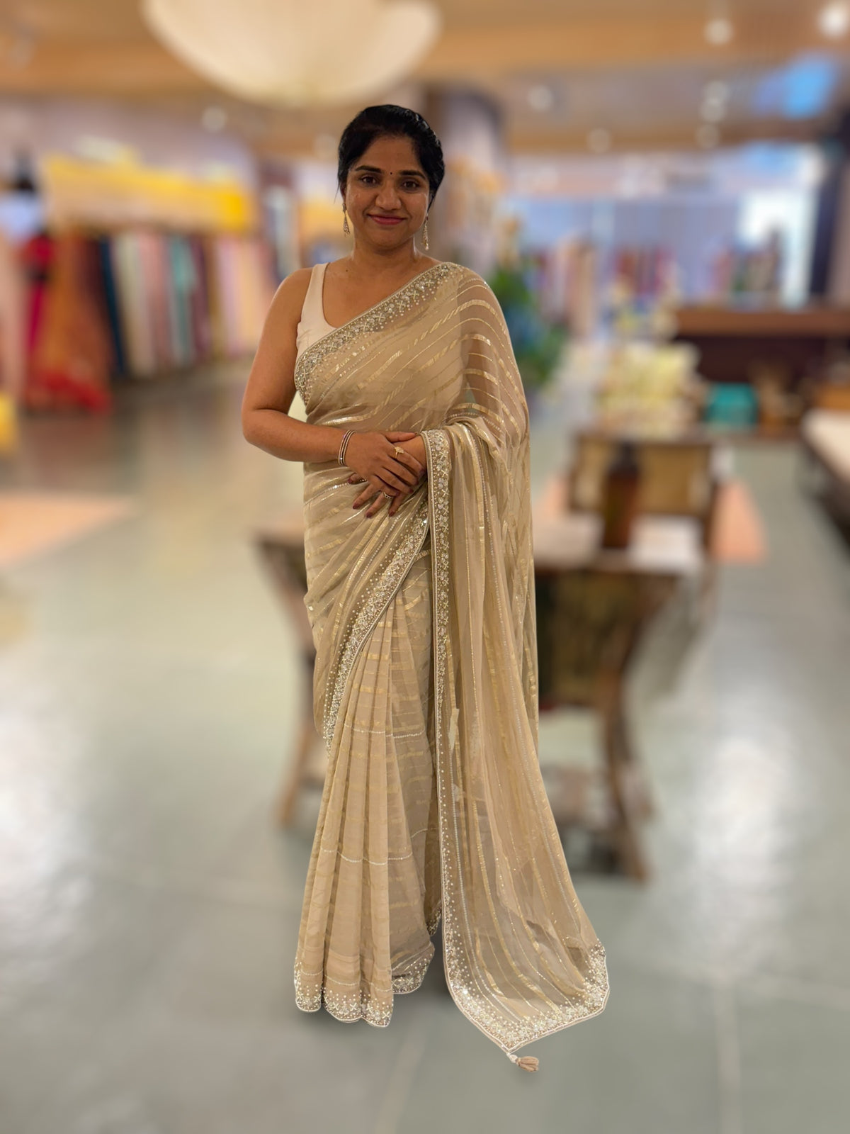 Beige chiffon saree with handwork borders and stitched blouse