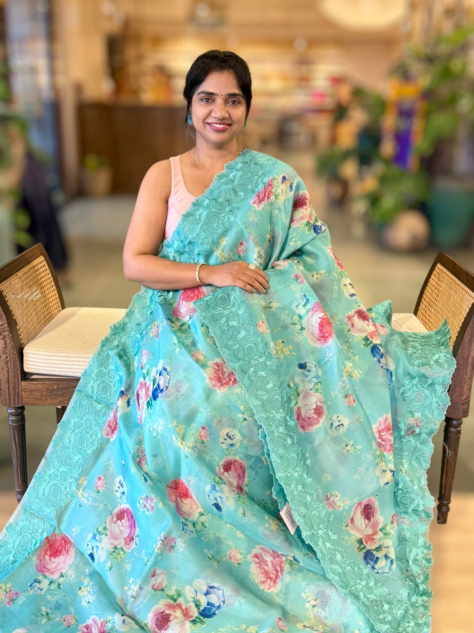 Teal Printed Organza Saree With Chantilly Lace Style Embroidered Border.