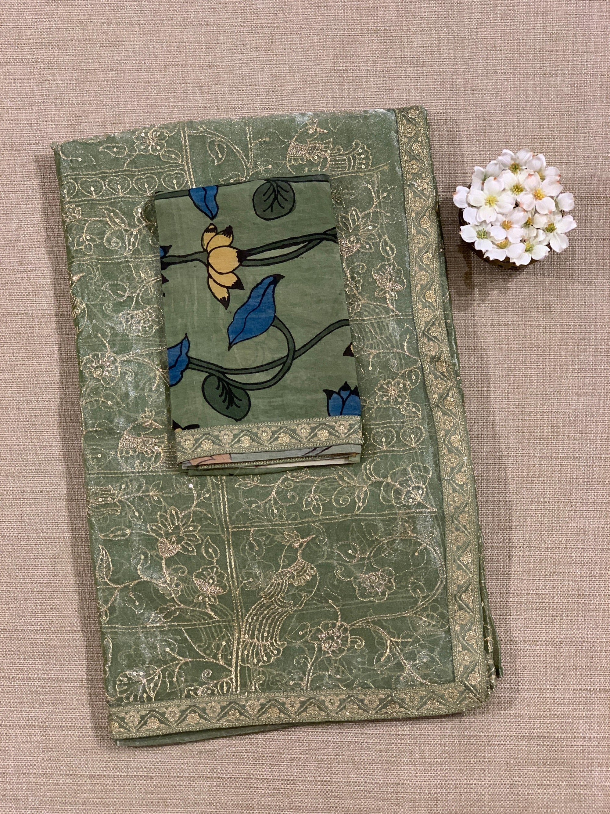 Light olive Tissue saree with Allover zari embroidery hemlined with sabyasachi borders & paired with pen kalamkari blouse