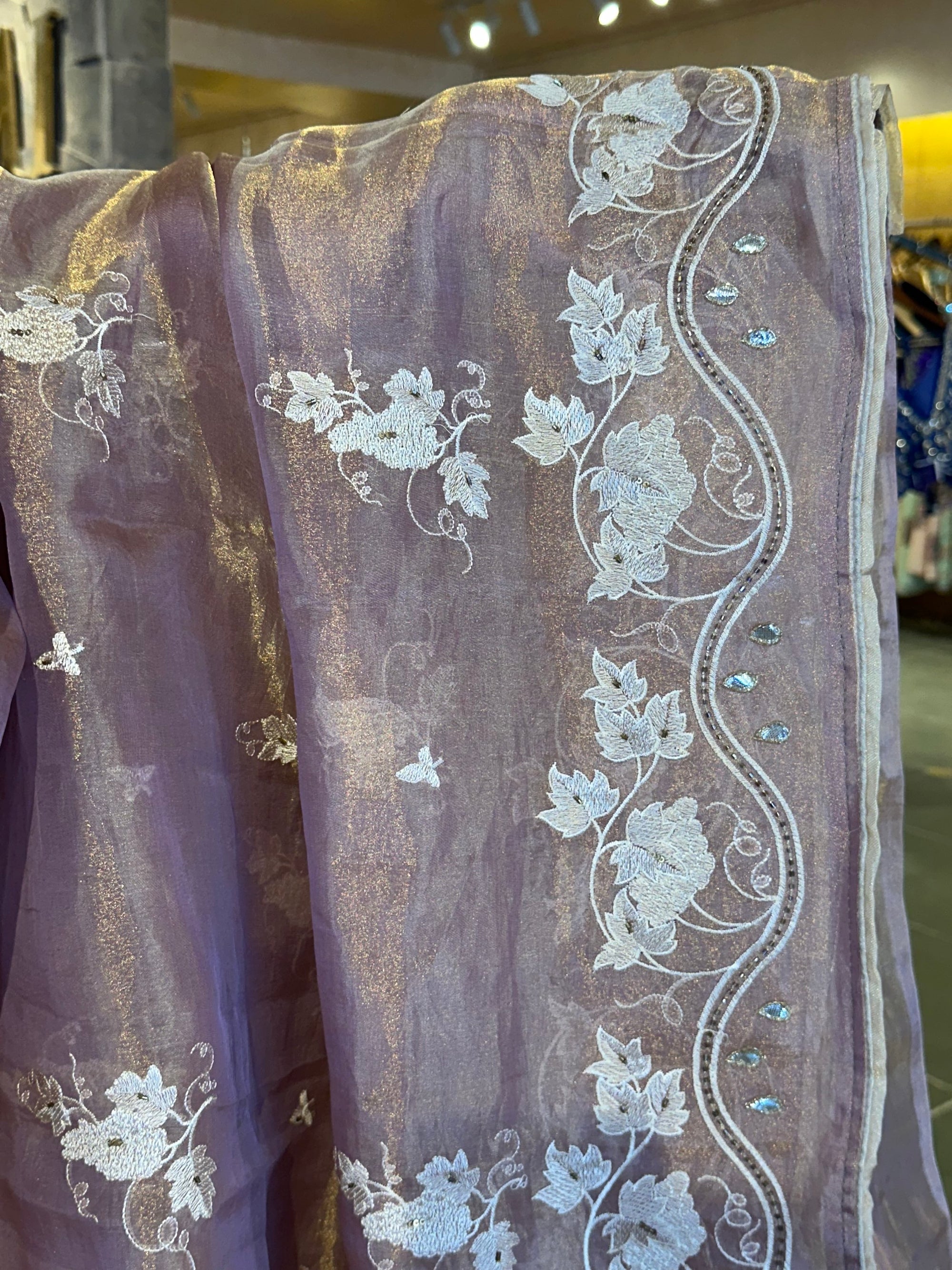 Mauve Tissue saree with allover embroidery and handwork highlighting .